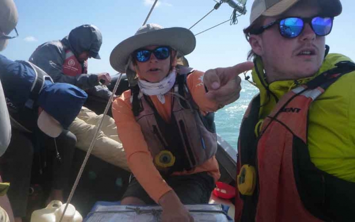 a person points toward a spot in the distance while another looks on 